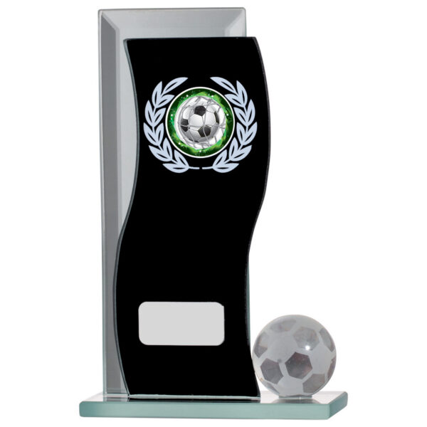Curved clear glass football award with black mirror panel featuring silver football emblem and laurel wreath design, accompanied by crystal football accent piece on glass base with engraving plate