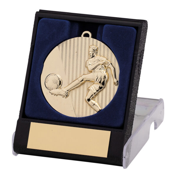 Gold football medal with embossed player kicking ball design and chevron textured background, displayed in black presentation box with blue velvet lining and gold engraving plate