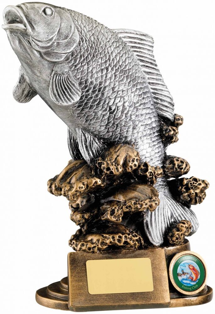 Premium fish trophy featuring detailed silver-finished fish sculpture with scale texture emerging from textured bronze coral base with fishing club medallion