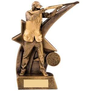 Golden bronze clay shooting trophy showing detailed figure of marksman in shooting stance with rifle, positioned against dynamic star backdrop design with blank engraving plate at base