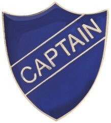Blue captain badge featuring shield-shaped design with deep blue enamel background, gold-tone border and raised gold lettering spelling CAPTAIN across diagonal banner