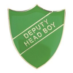 Green shield-shaped enamel pin badge with gold trim featuring white 'DEPUTY HEAD BOY' text displayed on diagonal banner against white background