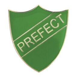 Green shield-shaped prefect badge with gold PREFECT text and decorative border trim on white background