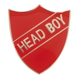 Red shield-shaped enamel badge with gold 'HEAD BOY' text across a diagonal banner, featuring polished edges and pin back fastening